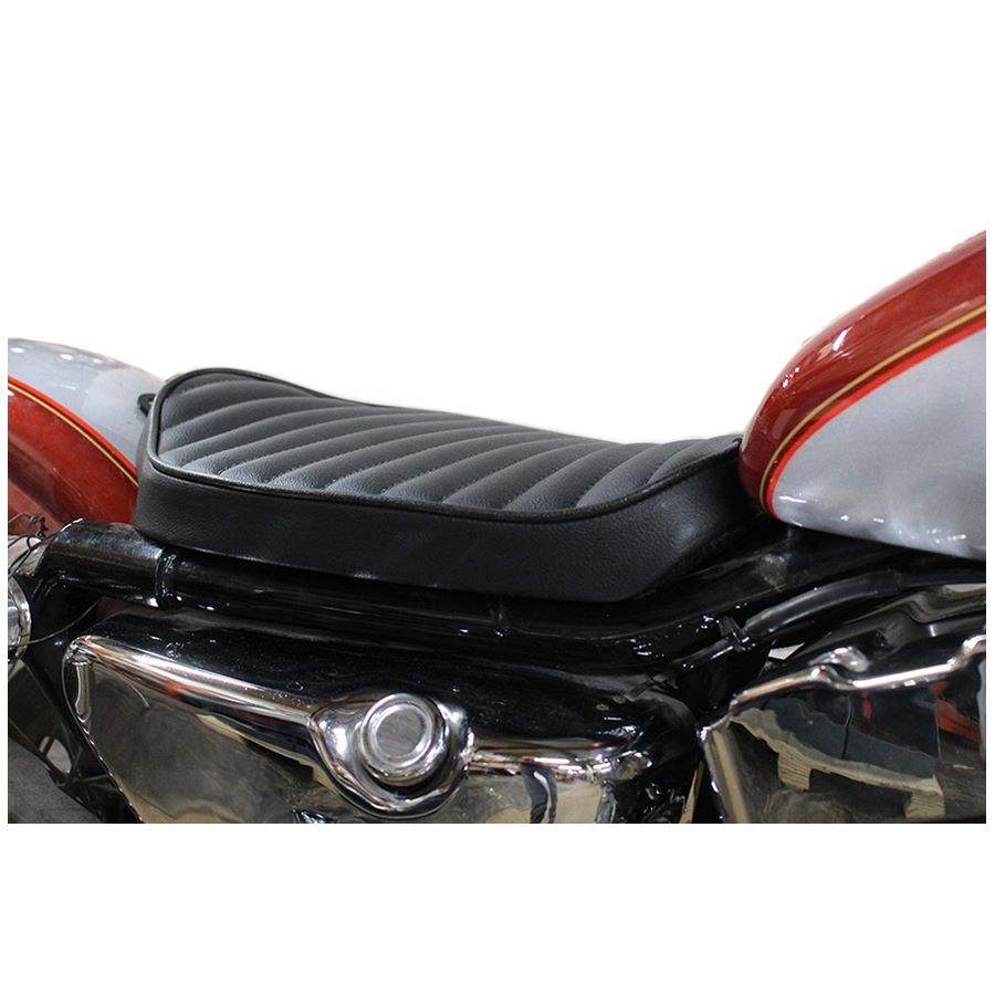 A close up of a Bates Solo Seat - Tuck and Roll Style - Black 1982-2003 Sportster on a motorcycle.