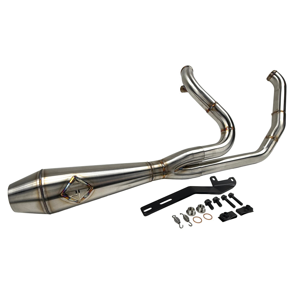 The SP Concepts Big Bore Exhaust M8 Touring FLT 2017-Present - Stainless features a polished stainless steel 2-into-1 design with visible welds and logo, resting on a gray workshop surface with an American flag-themed component in the background.