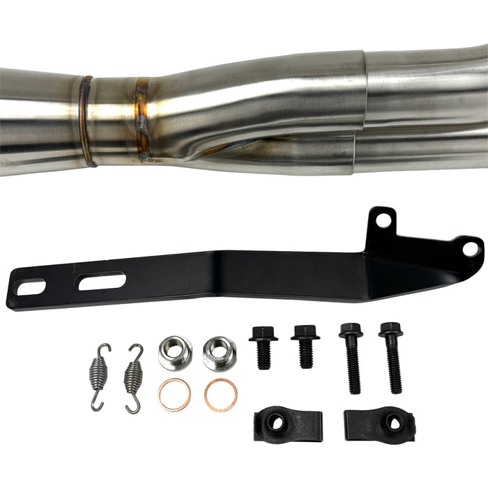 The SP Concepts Big Bore Exhaust M8 Touring FLT 2017-Present - Stainless features a polished stainless steel 2-into-1 design with visible welds and logo, resting on a gray workshop surface with an American flag-themed component in the background.