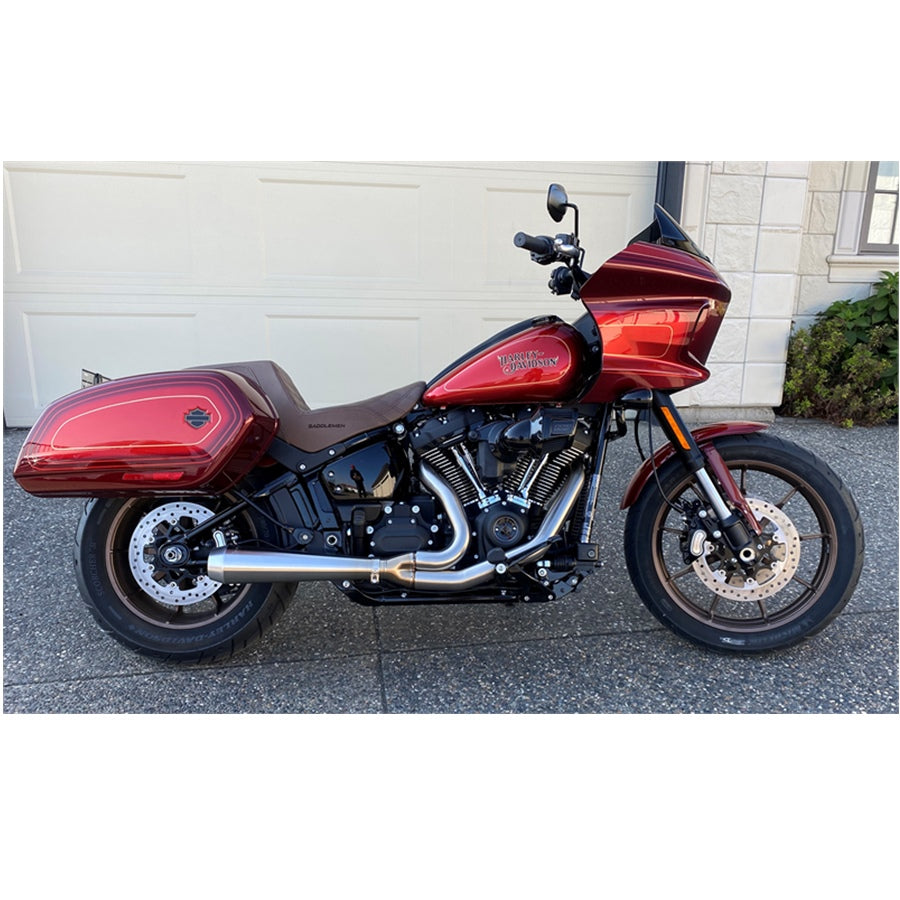 A red motorcycle with a Bassani Road Rage III 2-into-1 Stainless Exhaust 2018-21 FLSB, 2022-2024 FXL parked in front of a garage.