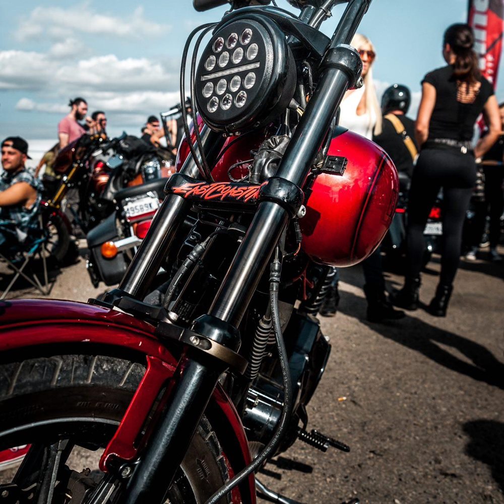 A red TC Bros. motorcycle, fitting all 87-2015 Sportster XL models, is parked in a parking lot.