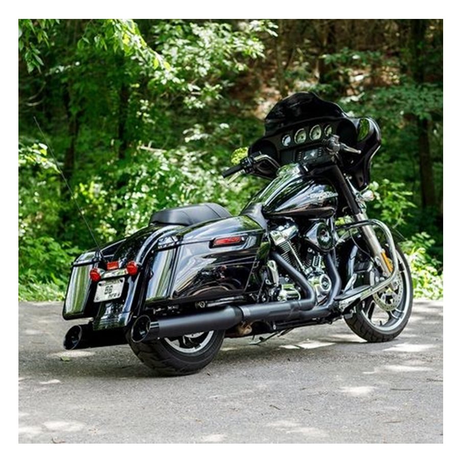 A black motorcycle parked in the woods, equipped with a 50 State Legal - Black Mk45 muffler with Black Cutlass End Cap for M8 Touring by S&S Cycle for enhanced performance.