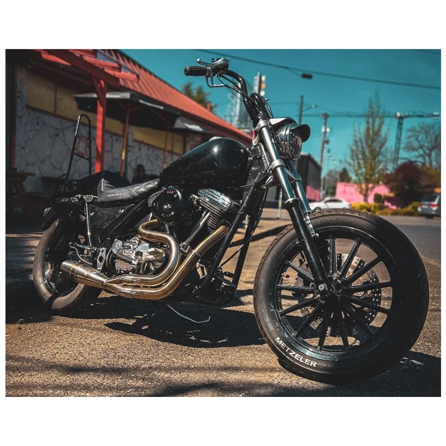 A performance motorcycle with a Sawicki Speed "Big Inch" Cannon 2 into 1 Pipe '82-'94 FXR Models - Stainless exhaust parked on the side of a street.