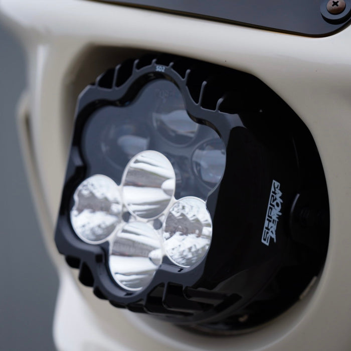 The Shark Demon™ 2 Performance LED Headlight Kit by Custom Dynamics is a round, black, DOT compliant headlight with an attached wiring harness and connectors. It also includes a separate mounting bracket with screws and rubber grommets, making it perfect for those seeking a reliable upgrade for their &