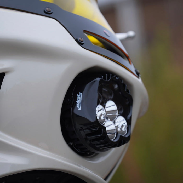 The Shark Demon™ 2 Performance LED Headlight Kit by Custom Dynamics is a round, black, DOT compliant headlight with an attached wiring harness and connectors. It also includes a separate mounting bracket with screws and rubber grommets, making it perfect for those seeking a reliable upgrade for their &