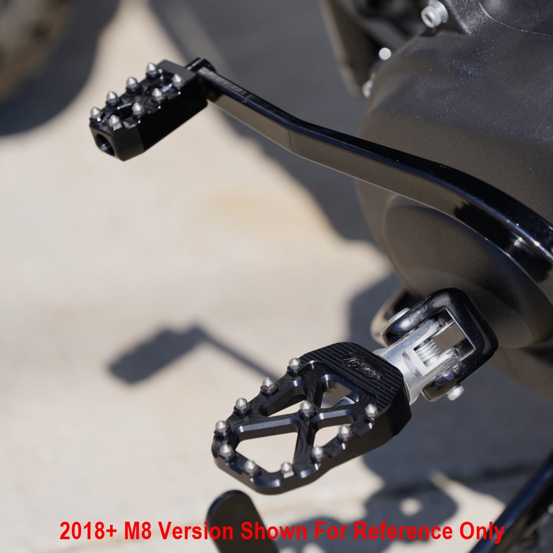 A motorcycle with a pair of TC Bros. Pro Series Black MX Foot Pegs for Harley Davidson Models for high traction and stability.