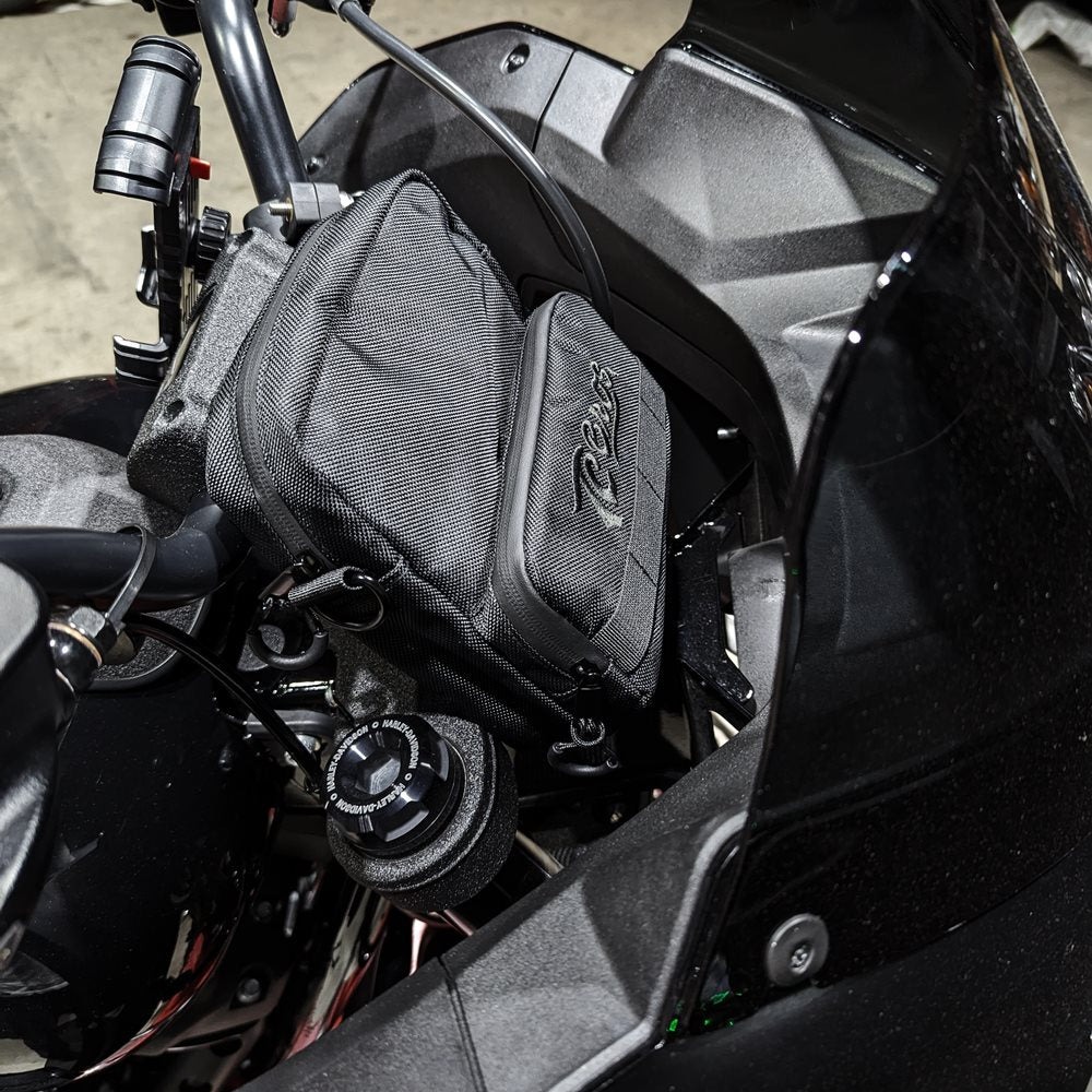 A TC Bros. Motorcycle Handlebar Bag attached to a motorcycle, for carrying riding essentials.