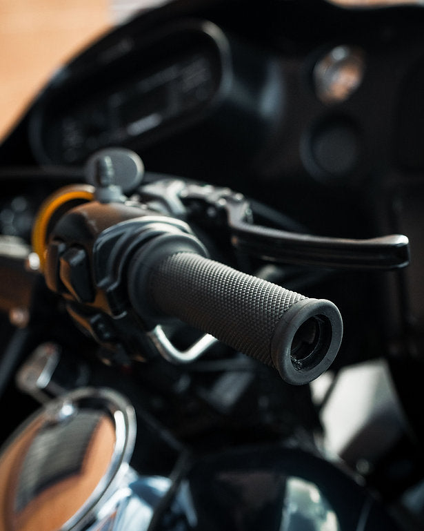 A close up of the handlebars on a motorcycle, emphasizing the Bear Grips - Motorcycle Grips by Speedwell and their ergonomics.