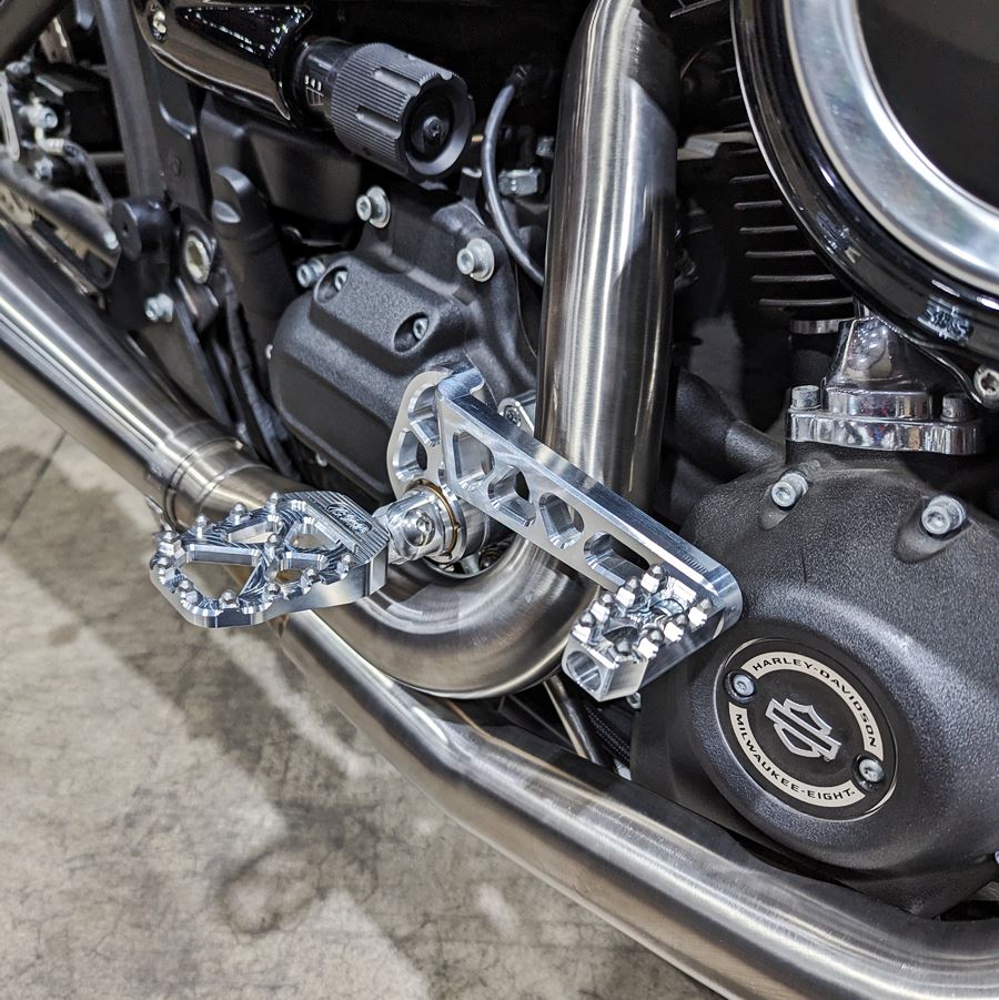 A close up of a motorcycle with TC Bros. Pro Series MX Foot Pegs for Harley Davidson Models and Pro Series Mid controls.