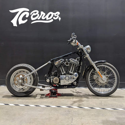 A Sportster Hardtail Kit For 2004-2013 by TC Bros. (Weld On) fits Stock 130-150 Tire motorcycle with a black wall as a background.