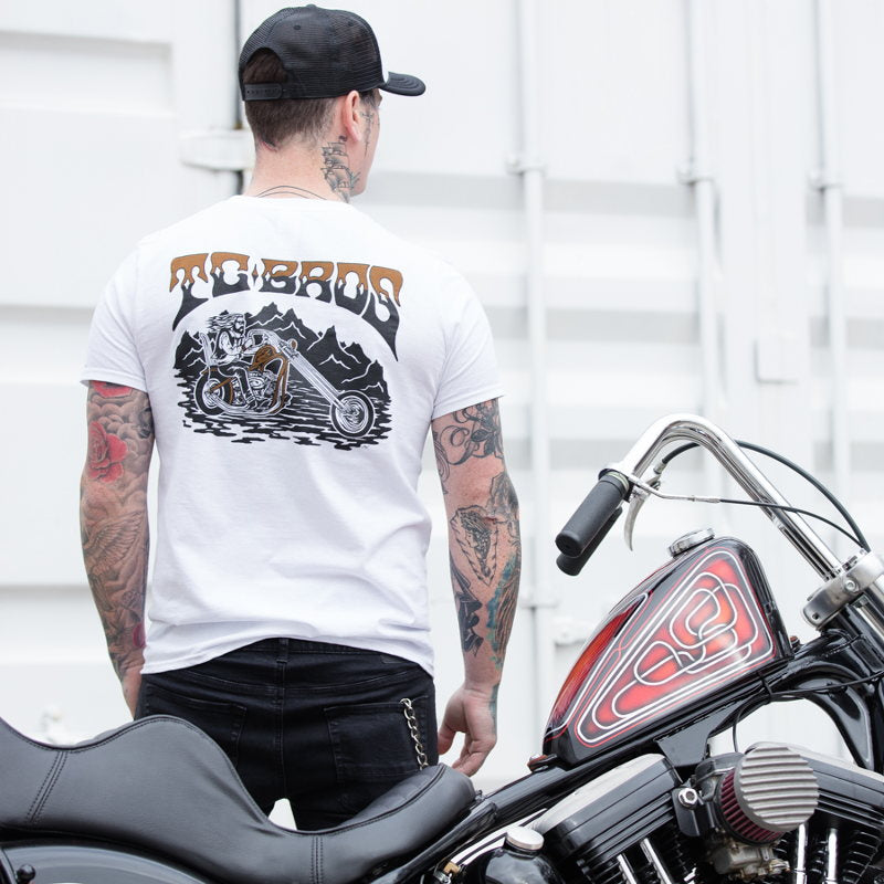 A drifter with tattoos standing next to a TC Bros. Drifter T-Shirt - White motorcycle.