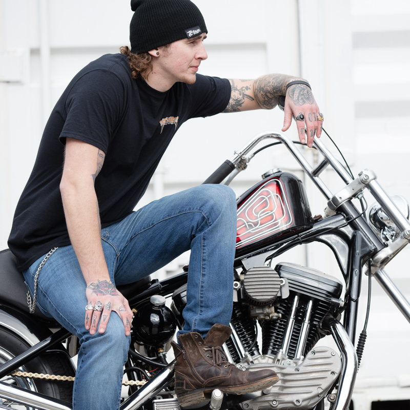 A man sitting on a TC Bros. Trippin' T-Shirt - Black motorcycle.