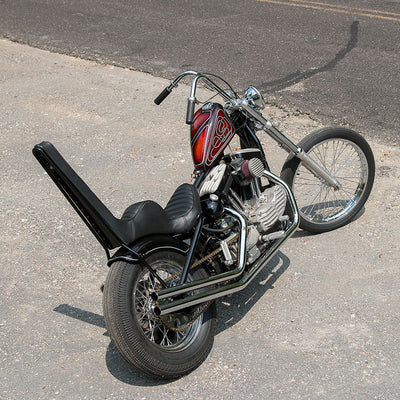 A TC Bros 5 inch Round Pill Style Chopper Oil Tank Universal Fit motorcycle, parked on the side of the road.
