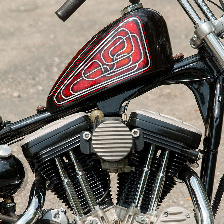 A close up of a motorcycle with a red and black engine featuring the TC Bros Air Cleaner/Carb Support Bracket for 91-06 Sportster aftermarket air filter and carb support bracket.