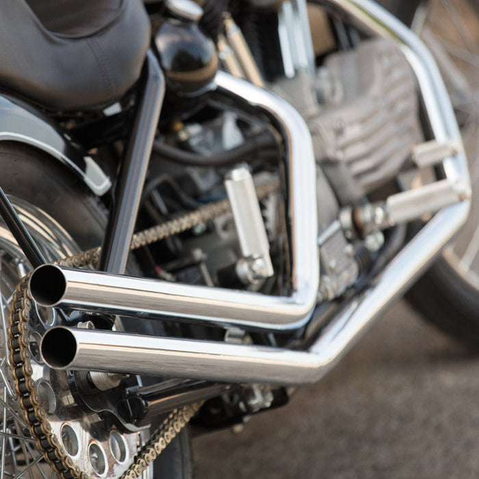 Moto Iron® Upsweep Exhaust System for Harley-Davidson Sportster 1986-2003 shown in chrome with mounting brackets and hardware, ideal for adding custom chopper style. Displayed on a white background.