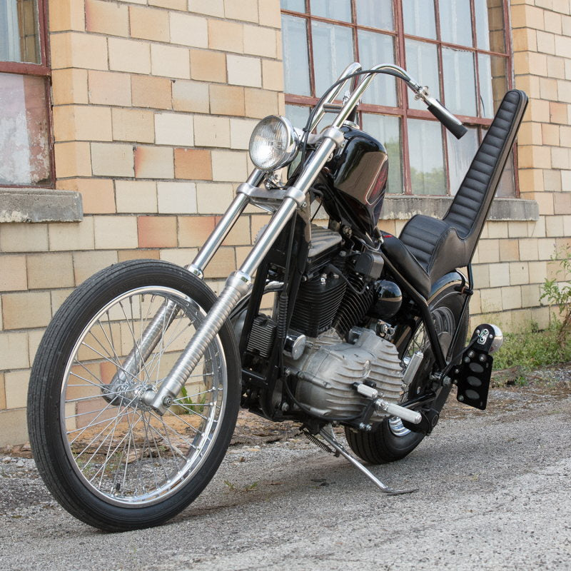 A motorcycle parked in front of a building with a Moto Iron® Chrome Front 40 Spoke Spool Hub Wheel 21 x 2.15 fits Harley (3/4" Bearings) chopper spool wheel.