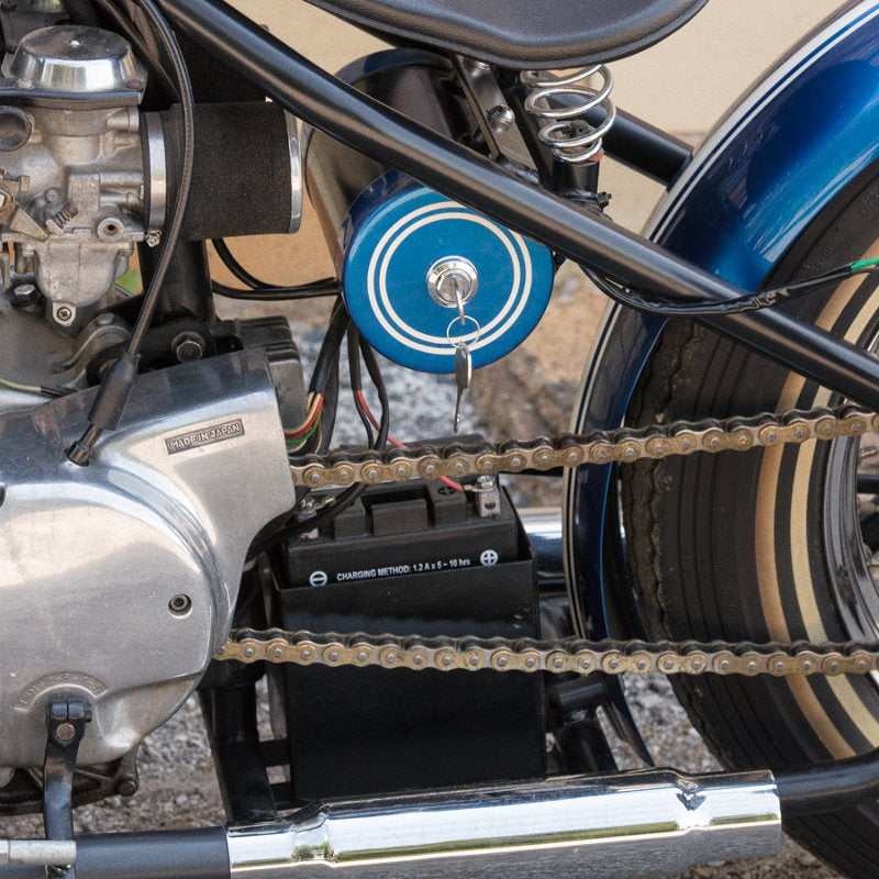 A blue motorcycle with a custom TC Bros. Battery Box (fits stock XS650 battery 12N14) attached to it.