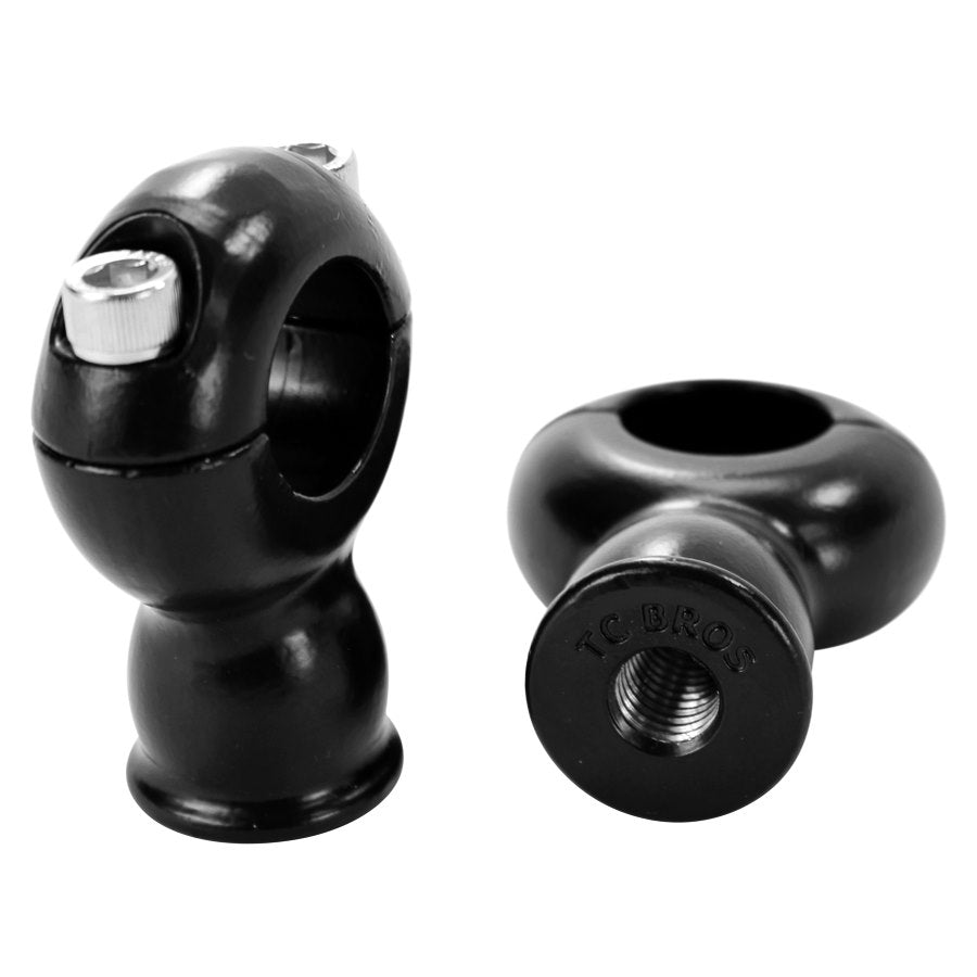 Two TC Bros. black plastic handlebar clamps on a white background, featuring TC Bros. 2" Classic Black Stainless Risers for 1" Diameter Handlebars.
