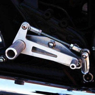 A close up of a Loaded Gun Custom Yamaha XS650 Rearsets by TC Bros. motorcycle with a metal handlebar.