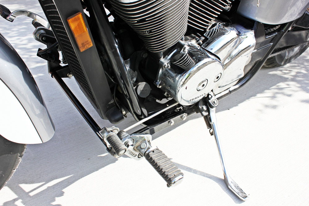 A close up of the front end of a TC Bros. Honda Shadow ACE 750 Forward Controls Extension Kit 1998-2003 VT750 models motorcycle featuring a forward controls extension kit.