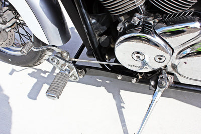 A close-up of a motorcycle engine with TC Bros. Honda Shadow ACE 750 Forward Controls Extension Kit 1998-2003 VT750, designed for Honda 750 Shadow ACE models and proudly manufactured in the USA.