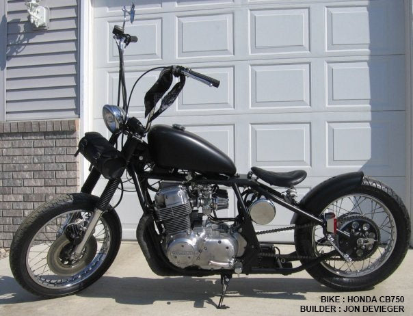 A Moto Iron® Rubber Mounted 3.1 Gal Sportster King Tank Fits 1995-03 motorcycle parked in front of a garage.