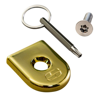 A Saddlemen gold key ring with a key and an ATAB Security Seat Screw.