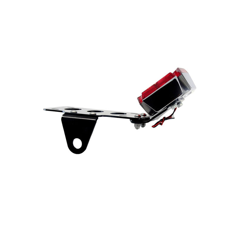 A black and red TC Bros. Maltese Cross Side Mount Tail Light/License Plate Bracket on a white background, featuring a versatile bracket for side mount license plate.