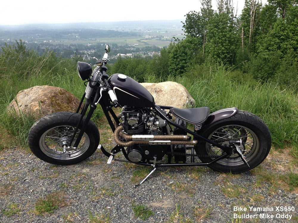 A black Moto Iron® Springer Kit For Yamaha XS650 stock length motorcycle parked on top of a hill.