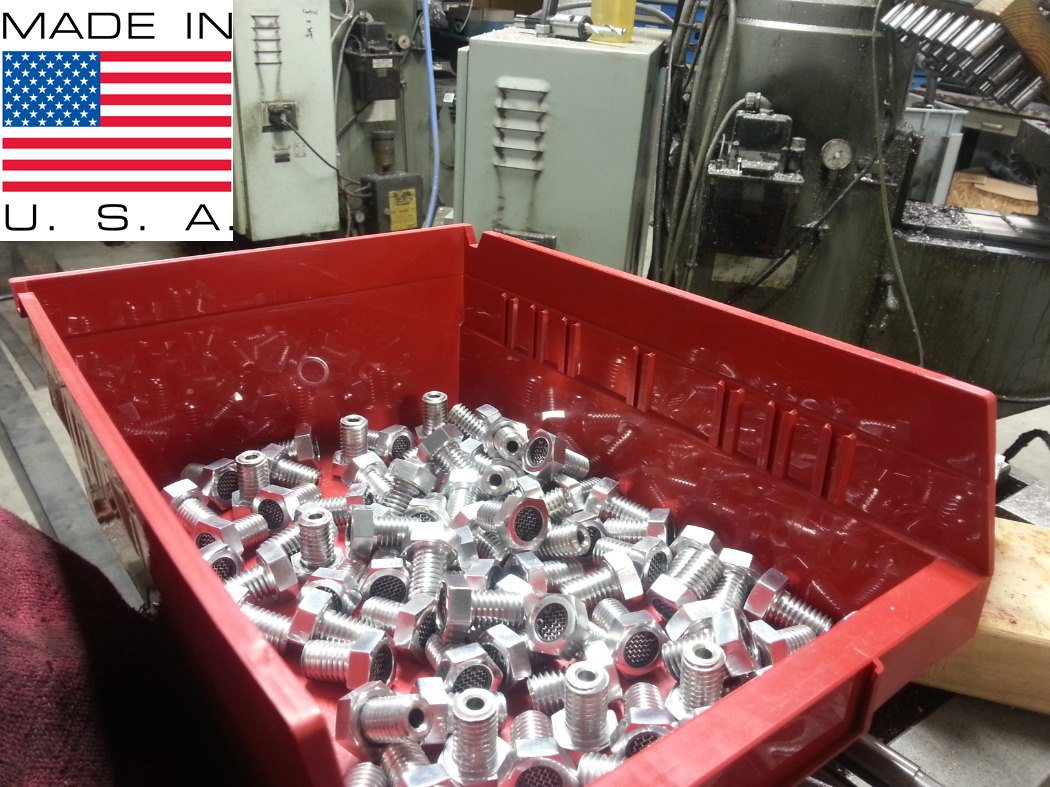 A TC Bros red box full of metal nuts and bolts in a factory, used for crankcase venting.