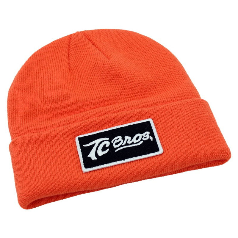 A TC Bros. Classic Beanie - Blaze Orange with an embroidered patch logo on it.