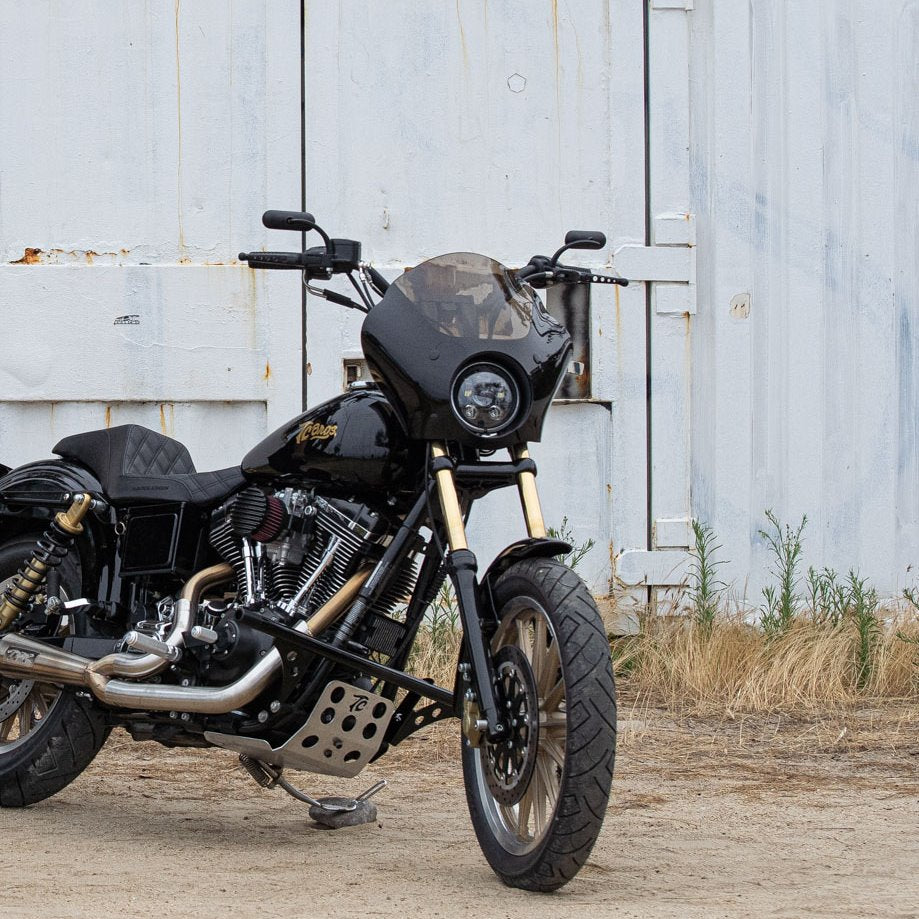 A black Shinko cruiser motorcycle parked in front of a barn.