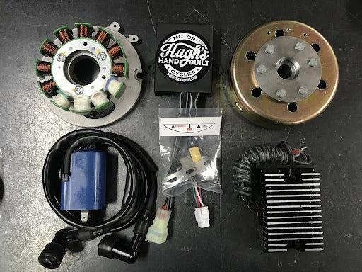 A set of motorcycle parts, including a motor and a Hughs Handbuilt HHB Complete XS650 PMA Charging & CDI Ignition System.