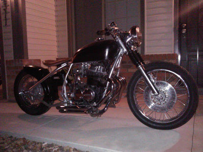 A TC Bros. Honda CB750 chopper parked in front of a house.