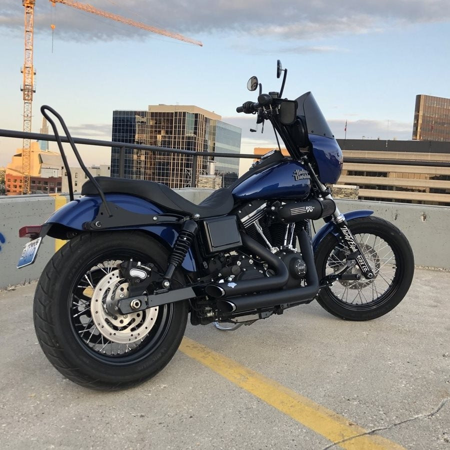 A blue TC Bros. Dyna 06-17 Kickback Sissy Bar Black motorcycle parked in a parking lot.