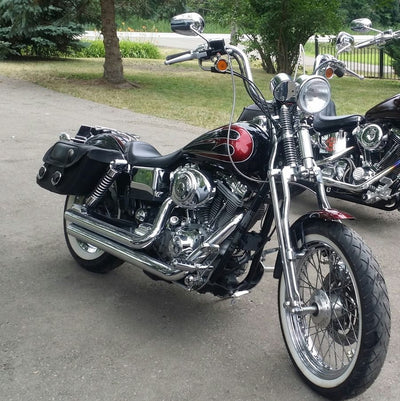 Two Moto Iron® Wishbone Springer Front End for Harley Davidson Dyna 91-17 & Sportster 04-Up (Stock Length, Black) motorcycles parked on the side of the road.
