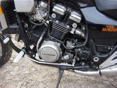 A close up of the engine of a TC Bros. Honda Magna V65 Forward Controls Kit motorcycle with a 1100cc capacity.