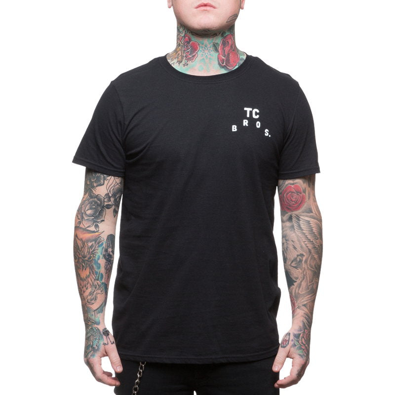 A man with tattoos wearing a TC Bros. Devil T-Shirt - Black.