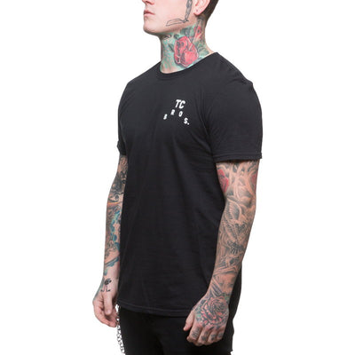 A man wearing a black TC Bros. Devil T-Shirt.