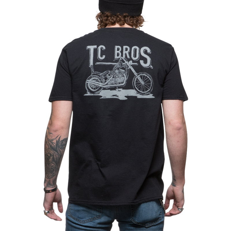 The back of a man wearing a TC Bros. Sketchy T-Shirt - Black that says TC Bros.
