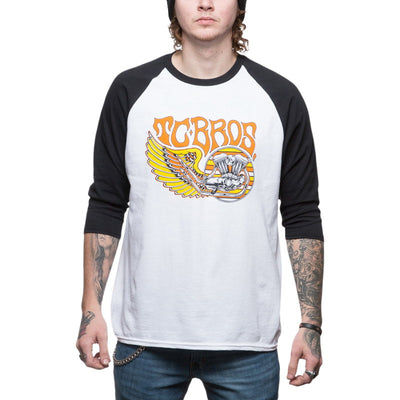 A man wearing a TC Bros. Wing Raglan baseball t-shirt with a wing on it.