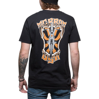 The back of a man wearing a TC Bros. Trippin' T-Shirt - Black, which features an orange and black design.