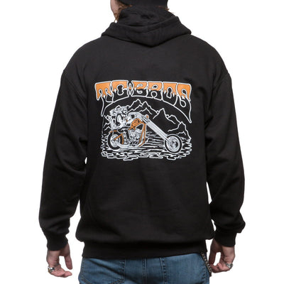 The man is wearing a black TC Bros. Drifter Zip Hoodie with a motorcycle on it.