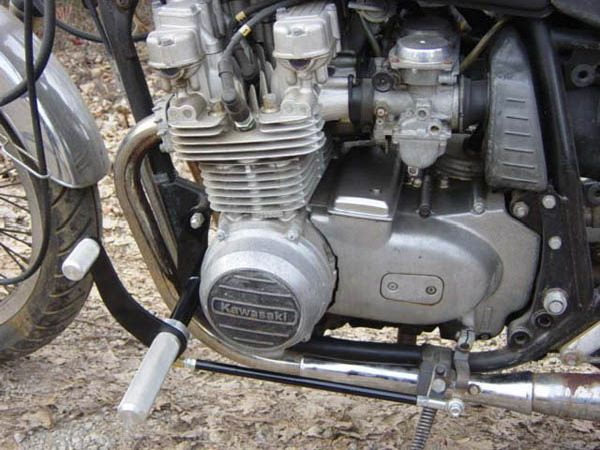 The TC Bros. Kawasaki KZ650-KZ750 Forward Controls Kit of a motorcycle is parked in the dirt.
