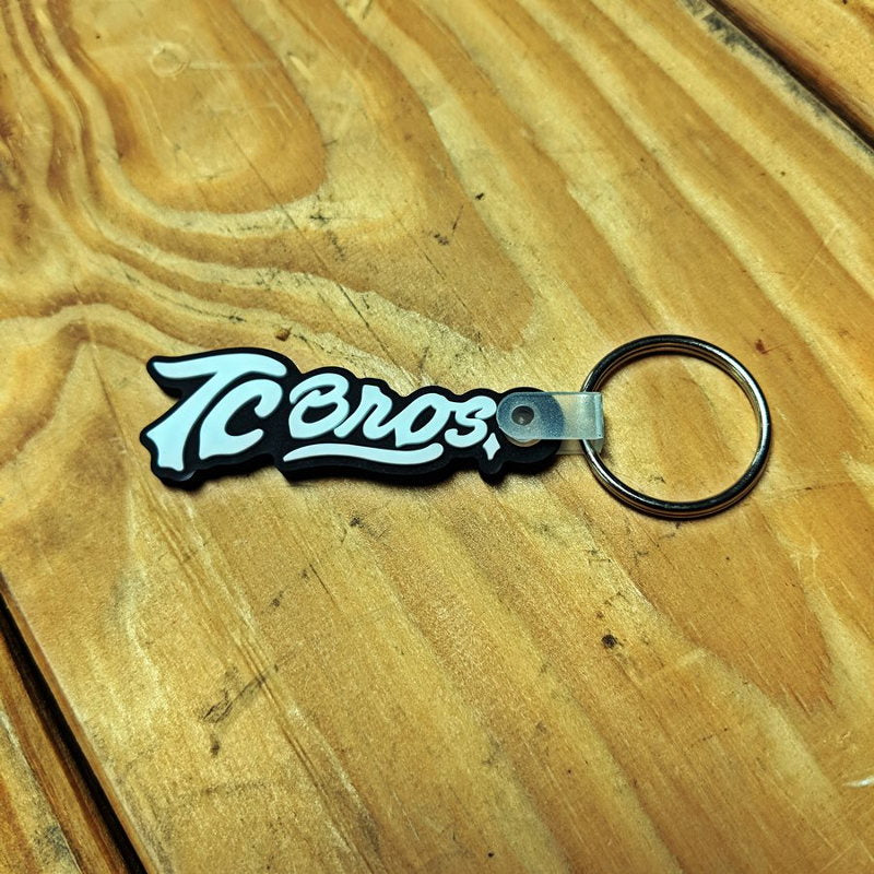 A 3D molded rubber TC Bros. Logo Keychain with the word teros on it.