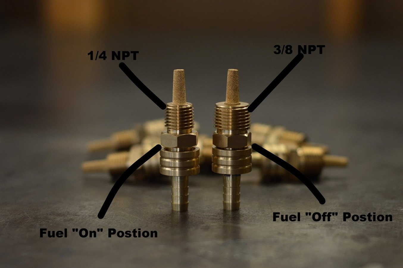 A set of 1/4" NPT Male Brass Fuel Petcocks by Prism Supply Co on a table.