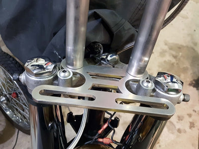 A close up of the handlebars on a Pangor Cycles Kneiss Rack Luggage Rack for 1960-Present Harley-Davidson Hydraulic Front Ends motorcycle.