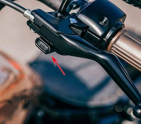A close up of the Drag Specialties LED Handlebar Marker Lights 00-14 Softail, 99-17 Dyna, 96-03 Sportster - Black on a motorcycle featuring high-intensity amber LEDs.