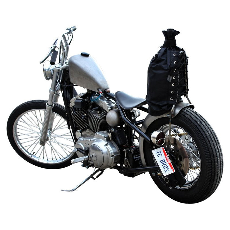 A black motorcycle with a black bag attached to it, featuring TC Bros. 1" Whiskey Handlebars - Black triple trees.