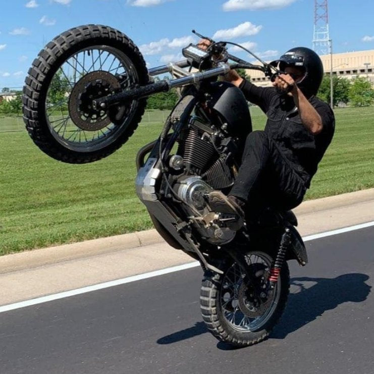 A man doing a trick on a TC Bros. Sportster Skid Plate 1991-2003 Models - Aluminum motorcycle made in the USA.